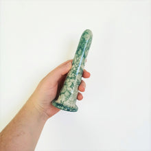 Load image into Gallery viewer, A hand holds a 6 inch classic dildo in a dark green bubble pattern in front of a white background.